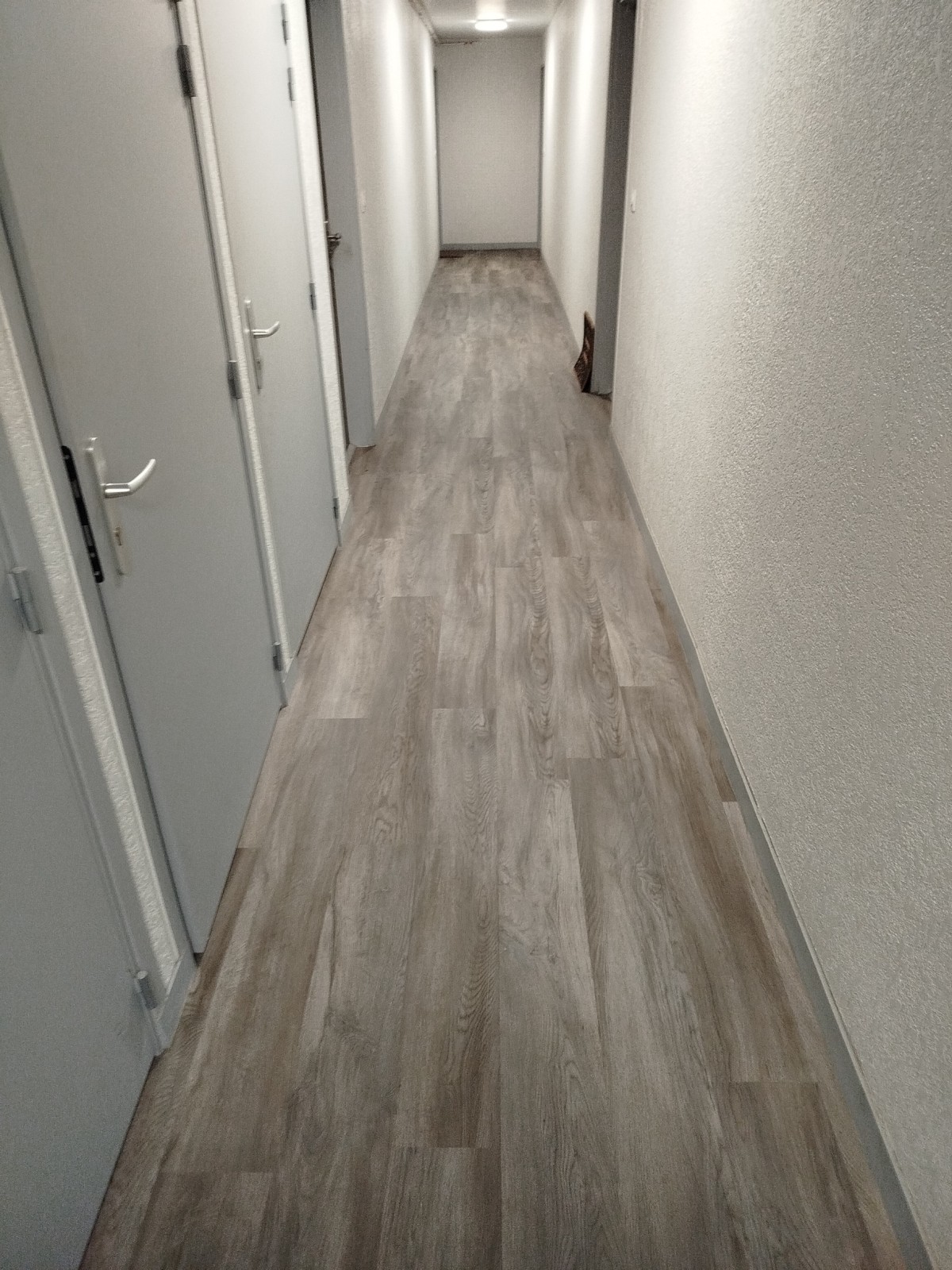 Travaux de revêtement de sol dans un couloir d'une résidence sur le secteur d'Isneauville 