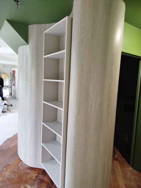 pose un revêtement mural imitation bois sur le secteur d'houppeville