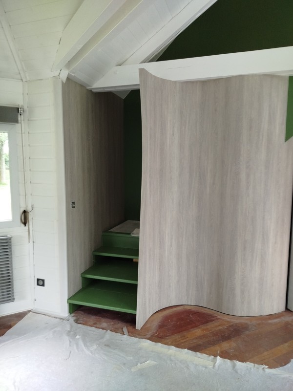 pose un revêtement mural imitation bois sur le secteur d'houppeville