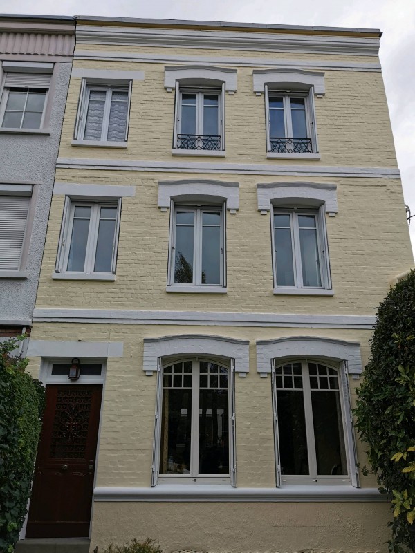 Ravalement de façade sur une ancienne maison en brique à Rouen.
