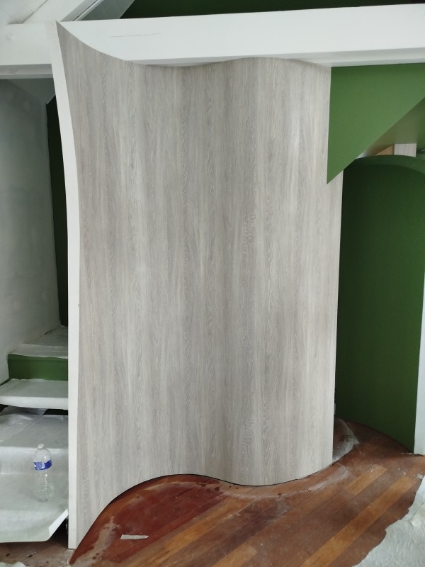 pose un revêtement mural imitation bois sur le secteur d'houppeville